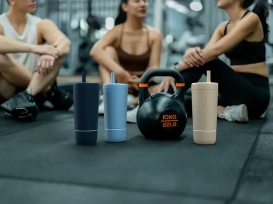 Three Quantum Bottles standing together on a gym floor at the start of a session